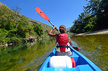 Young woman kayaking in Sella River, Asturias, Spain