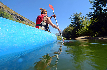 Young woman kayaking in Sella River, Asturias, Spain