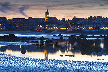 Rocky beach and village at dusk. Trengandin beach. Noja, Cantabria. Spain, Europe.