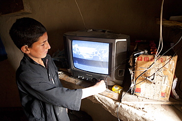 Afghan kids watching TV in a slum in Kabul