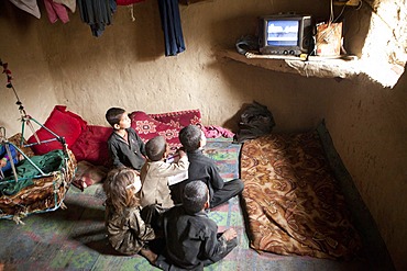 Afghan kids watching TV in a slum in Kabul