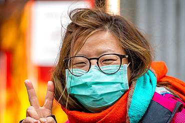 Shanghai, China, 27th Jan 2020, A woman wearing a mask gives a peace sign in the Xintiandi district