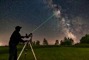 Me aiming the A&M 80mm refractor on the Astro-Tech Voyager mount at the Milky Way with its laser pointer finder showing the way. I am aiming at M11 in Scutum.