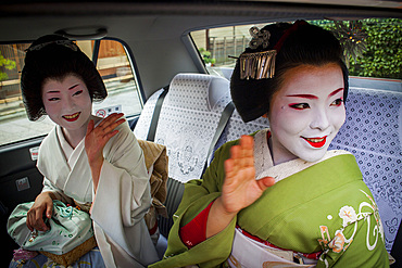 Fukuyu,geisha and Fukukimi,'maiko' (geisha apprentice)in taxi going to work.They say goodbye at Oka san. Geisha's distric of Miyagawacho.Kyoto. Kansai, Japan.