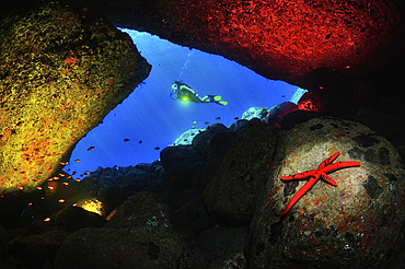 Diver and artistic lighting shot of the cave of Scilla, Italy