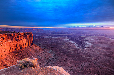 Cloudy sunrise over Buck Canyon, the White Rim & the La Sal Mountains, Canyonlands National Park, Moab, Utah. Viewed from the Buck Canyon Overlook in the Island in the Sky District of Canyonlands NP.