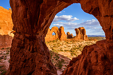 The Parade of Elephants and the back of Double Arch framed by Cove Arch in Arches National Park, Moab, Utah.