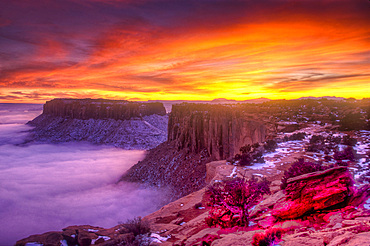 Colorful sunset over Junction Butte and Grandview Point with a sea of clouds below. Canyonlands National Park, Utah.