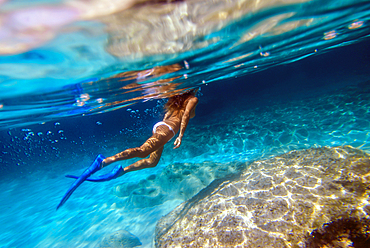 Woman underwater in Mitjorn beach in Formentera, Spain