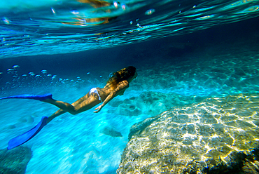 Woman underwater in Mitjorn beach in Formentera, Spain