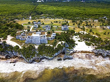 Aerial views of El Castillo and the Ruins of the Mayan temple grounds at Tulum, Quintana Roo, Yucatan, Mexico. Tulum is the site of a pre-Columbian Mayan walled city which served as a major port for Coba, in the Mexican state of Quintana Roo. The ruins are situated on 12 meter 39 ft tall cliffs along the east coast of the Yucatán Peninsula on the Caribbean Sea in the state of Quintana Roo, Mexico. Tulum was one of the last cities built and inhabited by the Maya; it was at its height between the 13th and 15th centuries and managed to survive about 70 years after the Spanish began occupying Mexico. Old World diseases brought by the Spanish settlers appear to have resulted in very high fatalities, disrupting the society, and eventually causing the city to be abandoned.