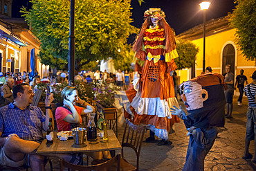 Gigantona dress in La Calzada a gastronomic street in Granada Nicaragua with lots of tourists and locals enjoying fine food outdoors. Granada - Nicaragua