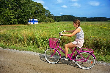 Riding a bicycle in Nagu or Nauvo island in Väståboland in Pargas in Southwest Finland Turku archipelago. The archipelago ring road or Saariston rengastie is full of things to see, do and do. The Archipelago Trail can be taken clockwise or counter clockwise, starting in the historical city of Turku, and continuing through rural archipelago villages and astonishing Baltic Sea sceneries. The Trail can be taken from the beginning of June until the end of August.