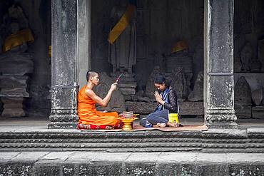 Monk blessing a woman, in Angkor Wat, Siem Reap, Cambodia