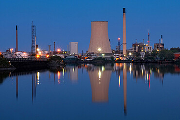 Stanlow Oil Refinery reflected in the Manchester Ship Canal at night, near Ellesmere Port, Cheshire, England, United Kingdom, Europe