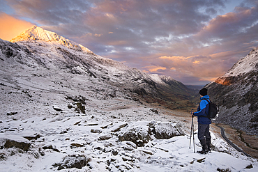 Walker looking to Crib Goch and the Llanberis Pass at dawn in winter, Snowdonia National Park, Eryri, North Wales, United Kingdom, Europe