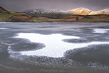 Ice Patterns on frozen Llyn y Dywarchen backed by Foel Goch and Foel Gronin in winter, Snowdonia National Park (Eryri), North Wales, United Kingdom, Europe