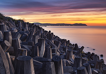 Sea Defences on Llanddulas Beach backed by The Great Orme at sunset, Llanddulas, near Abergele, Conwy County Borough, North Wales, United Kingdom, Europe