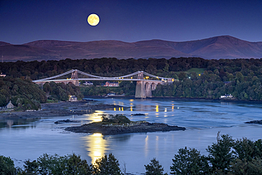 Super Harvest Moon rising over the Menai Bridge and Menai Strait, Anglesey, North Wales, UK