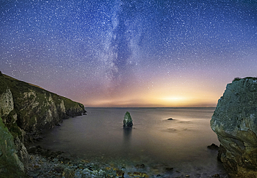 The Milky Way and Starry night sky over Gwenfaen’s Pillar, Porth Saint, near Rhoscolyn, Anglesey, North Wales, UK
