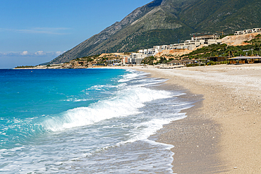 Ionian Sea, Drymades Beach, with large scale tourist development construction building work in the distance, Albanian Riviera, Dhermi, Albania, Europe