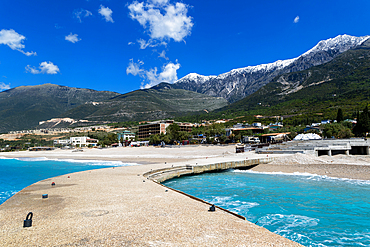 Tourist development construction building work view from Drymades Beach to Mount Cika snow capped mountain range, Dhermi, Albanian Riviera, Albania, Europe