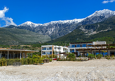 Tourist development construction building work view from Drymades Beach to Mount Cika snow capped mountain range, Dhermi, Albanian Riviera, Albania, Europe