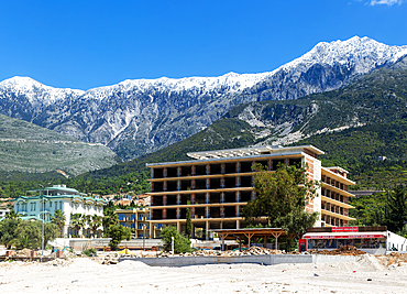 Tourist development construction building work view from Drymades Beach to Mount Cika snow capped mountain range, Dhermi, Albanian Riviera, Albania, Europe