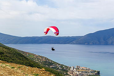 Paraglider taking off from mountainside above the Adriatic Sea at Vlore, Albania, Europe