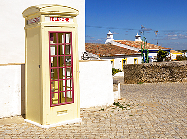 Old fashioned Telephone (Telefone) box kiosk in street of traditional Portuguese village, Cacela Velha, Algarve, Portugal, Europe