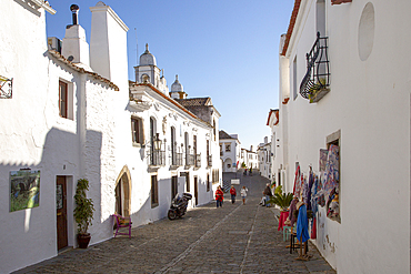 Historic cobbled street and whitewashed buildings in walled hilltop village of Monsaraz, Alto Alentejo, Portugal, Europe