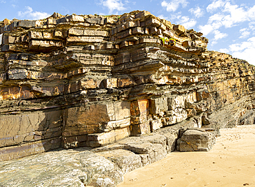 Tilted layers showing bedding planes in strata of sedimentary rock in coastal cliff at Odeceixe, Algarve, Portugal, Europe