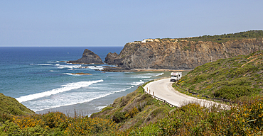 Motorhome parked at viewpoint of Atlantic Ocean waves breaking on rocky headland and bay with sandy beach, Praia de Odeceixe, Algarve, Portugal, Europe