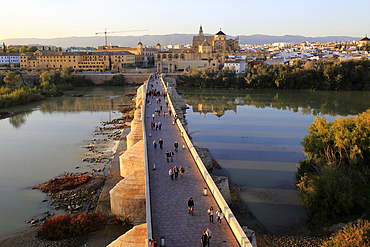 Roman bridge spanning river Rio Guadalquivir with Mezquita cathedral buildings, Cordoba, Spain