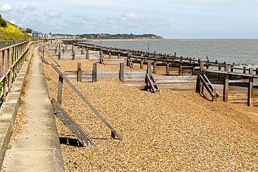 Wooden beach groynes to manage longshore drift, Felixstowe, Suffolk, England, UK view to Bawdsey Manor