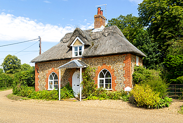 Flint and thatched historic country cottage former estate worker's home, Sutton, Suffolk, England, UK