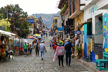 People walking along busy shopping street with mountain in distance, Tepoztlan, State of Morelos, Mexico, North America