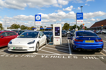 Electric vehicles charging Pod Point, Tesco Extra supermarket carpark, Swindon, Wiltshire, England, UK