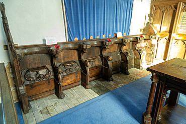 Carved decorated wooden misericord seats in church at Framsden, Suffolk, England, UK