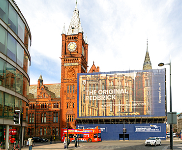 Victoria building clocktower renovation of art gallery, University of Liverpool, England, UK - red double-decker tour bus passing