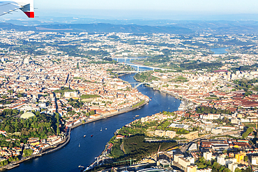Oblique aerial view from plane window over city of Porto, Portugal, Europe tip of aircraft wing visible