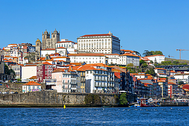 Cathedral on hilltop, historic riverside buildings on hillside of Ribeira next to River Douro, Porto, Portugal, Europe