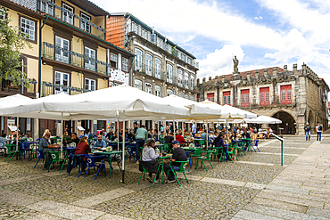 Tables and chairs, historic buildings in Largo da Oliveira square, city of Guimaraes, northern Portugal, Europe