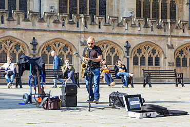 Busker musician performing in Bath Abbey church yard, city of Bath, north east Somerset, England, UK