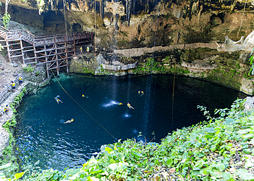 People swimming in Cenote Zaci, carboniferous limestone swallow hole pool, Valladolid, Yucatan, Mexico, North America