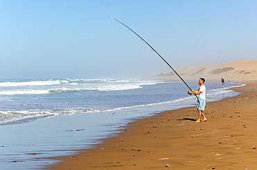 Fisherman standing by Atlantic Ocean, Mimid beach, Sidi Boufdail, Mirleft, Morocco, North Africa, Africa