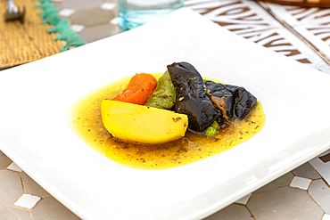 Tagine dish on white plate with potato carrot aubergine courgette and beef, Morocco, North Africa, Africa