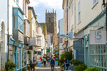 Shops in historic buildings along alleyway with tower of church of St. Saviour, Foss Street, Dartmouth, Devon, England, United Kingdom, Europe