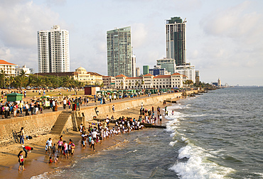 School children paddle in the sea on small sandy beach at Galle Face Green, Colombo, Sri Lanka, Asia