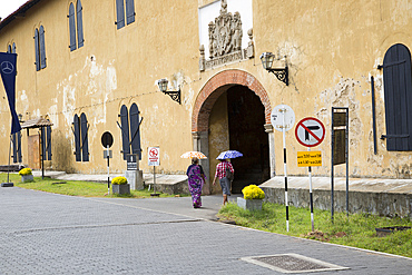 Women walking with umbrellas for shade towards the fort doorway exit in the historic town of Galle, UNESCO World Heritage Site, Sri Lanka, Asia